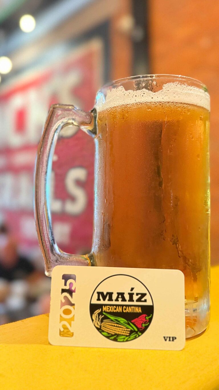 Closeup of a MAIZ VIP card set in front of a beer.